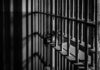 Black and white photo of jail cell bars.