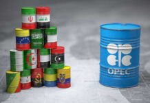 A stack of colorful oil barrels representing different countries next to an OPEC barrel
