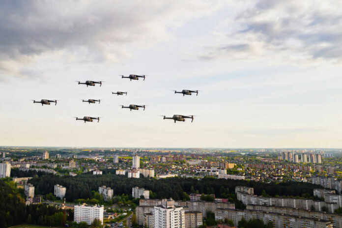 Drones flying over a cityscape under cloudy sky.