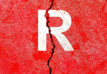 Cracked red wall with white letter R.