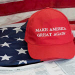 MAGA Civil War Erupts Over Iran Red Make America Great Again hat on American flag