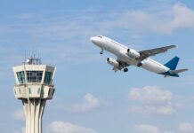 An airplane taking off near an airport control tower