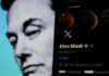 Elon Musks profile on mobile screen, blurred background face.