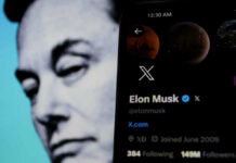 Elon Musks profile on mobile screen, blurred background face.