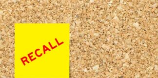Yellow sticky note with the word 'RECALL' on a corkboard
