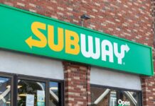 Subway restaurant sign displayed on a brick wall