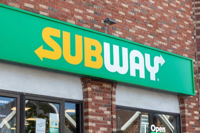 Subway restaurant sign displayed on a brick wall