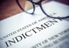 Close-up of an indictment document with glasses resting on it