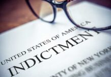 Close-up of an indictment document with glasses resting on it