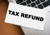 A card displaying the words 'TAX REFUND' placed on a laptop keyboard