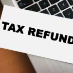 A card displaying the words 'TAX REFUND' placed on a laptop keyboard