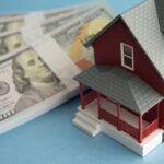 Trump Rewrites Mortgage Rules — Everything Just Changed A model red house next to stacks of hundred-dollar bills
