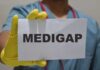 Medical professional holding a sign that says 'MEDIGAP'