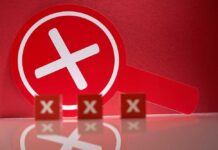 A red magnifying glass with a cross symbol against a red background