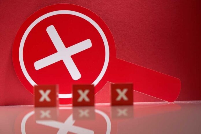 A red magnifying glass with a cross symbol against a red background