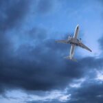 An airplane flying through a cloudy sky