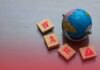 A small globe next to wooden blocks spelling 'WAR' with a warning symbol