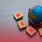 VIDEO: Trump’s New War Announcement A small globe next to wooden blocks spelling 'WAR' with a warning symbol
