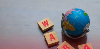 A small globe next to wooden blocks spelling 'WAR' with a warning symbol