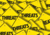 Yellow signs with the word threats overlapping