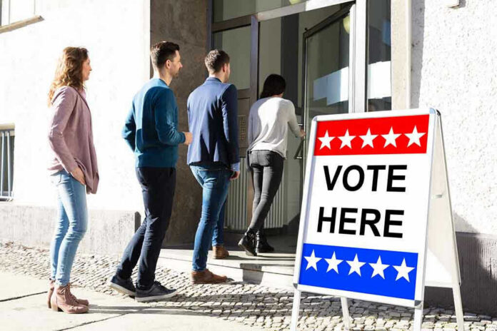 1389236000 People entering building with Vote Here sign nearby.