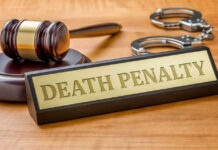 Gavel handcuffs and death penalty sign on table