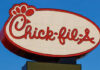 Chick-fil-A Storm: Sabbath Firing Sparks Legal Battle Chick-fil-A restaurant sign illuminated against a blue sky