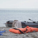 Missing Wife Sparks High-Seas Drama An inflatable boat on the beach with a life jacket and clothes nearby
