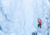 American Climber KILLED Moments After Historic Summit A climber in an orange jacket scaling a frozen ice wall
