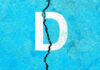 White letter D on cracked blue surface.