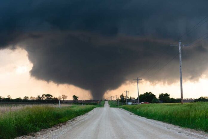 A tornado forming in a rural area with dark storm clouds overhead