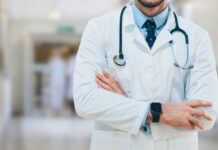 TrumpRx Pricing Expands to Hundreds of Drugs A doctor in a white coat with a stethoscope standing with arms crossed