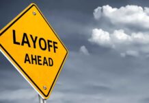 Shocking AI Layoffs Surge: 78,557 Jobs Gone! Yellow warning sign indicating layoffs ahead against a cloudy background