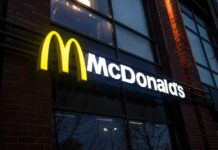 Illuminated McDonald's sign on a brick building at night