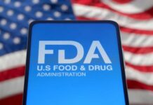 FDA Boss QUITS — Brutal War Exposed Inside Agency FDA logo displayed on a smartphone with an American flag background