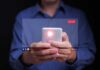 Person holding a smartphone with a live streaming interface