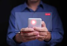 AI Voice Scam Stuns Mom – $5,400 Gone! Person holding a smartphone with a live streaming interface