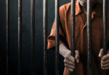 Spy Execution: Hidden Truths Behind the Noose? Man in orange prison uniform behind jail bars.