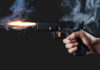 VIDEO: Bullets Hit 12 During American Festival A hand holding a gun with smoke and a flash from the muzzle
