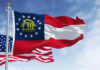 Georgia state flag and U.S. flags waving together.