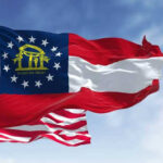 Georgia state flag and U.S. flags waving together.