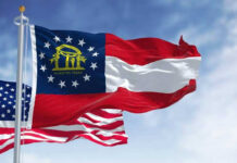 Georgia state flag and U.S. flags waving together.