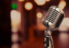 Vintage microphone on a blurred, warm-toned background.