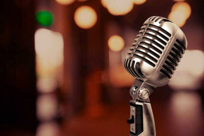 Vintage microphone on a blurred, warm-toned background.