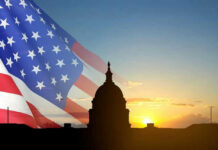Capitol building silhouette with American flag at sunrise.