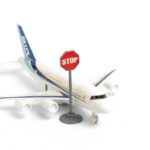 War Fuel Shock Hits U.S. Flights – Routes Canceled A toy airplane next to a stop sign