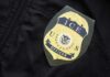 Border Hawk Tapped — Lib Panic Erupts Close-up of an ICE officer badge on a black jacket
