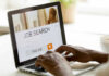Record Exodus From Work Stuns Wall Street Person searching for jobs on a laptop.