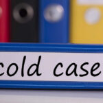 Cold Case Blood Drop Points to Friend Blue binder labeled 'cold case' with other colored binders in the background