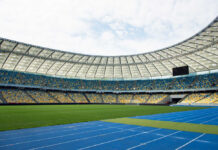 Empty stadium with blue running track and green field
